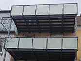 Balcon avec structure portante en profilés d'acier et garde-corps avec verre