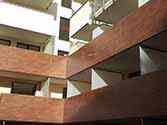 Balustrade de balcon avec remplissage de panneaux de HPL (Strafié Haute Pression). Cloison en verre laiteux avec un cadre en acier
