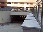 Entrée du garage souterrain avec toit en panneaux de polycarbonate avec construction de soutien en acier et garde-corps verre avec main courante en inox