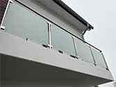 Balustrade de balcon. Garde-corps en verre avec main courante et des poteaux en inox