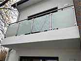 Balustrade de balcon. Garde-corps en verre avec main courante et des poteaux en inox