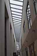 Toit en verre recouvrant le passage entre l'immeuble de bureaux et la zone de stockage. 
Panneaux de verre posés au-dessus de poutres en acier galvanisé montés sur le toit.