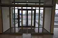 Système de porte coulissante en aluminium à l'entrée d'un bâtiment.