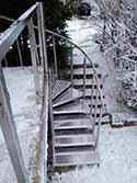 Escalier extérieur en inox avec marches en tôle d'aluminium. Garde-corps avec main courante et poteaux en inox